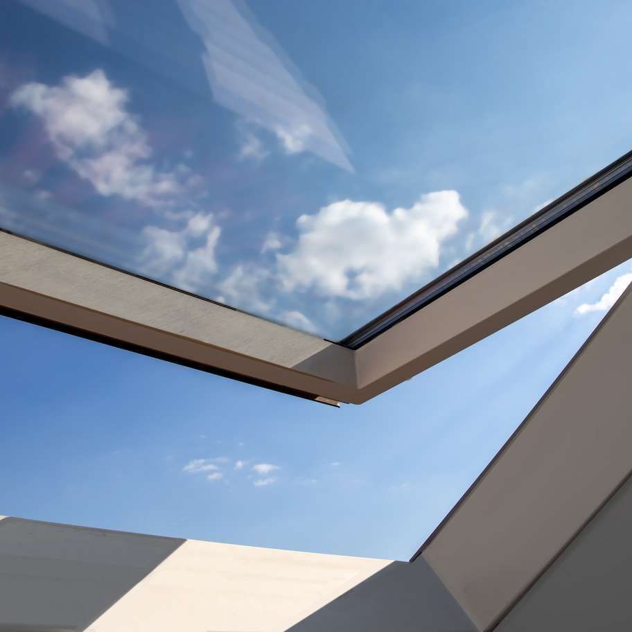 Skylight framing a bright blue sky with white clouds.