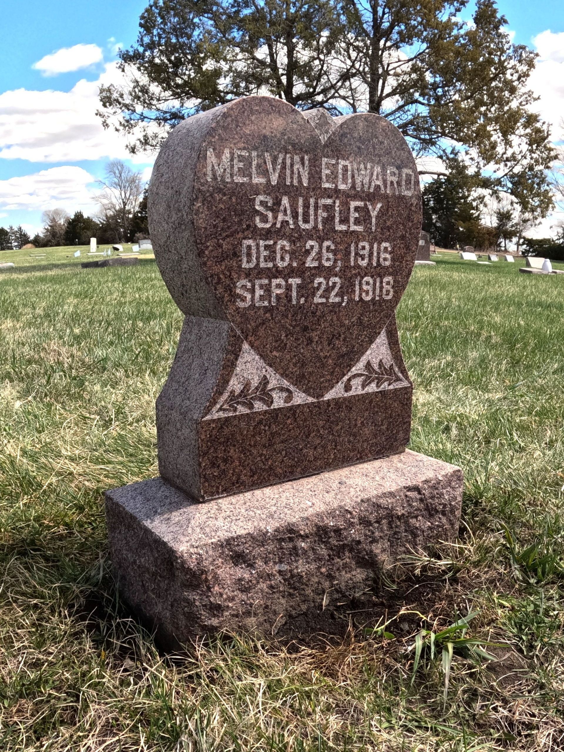 A repaired gravestone for melvin edward saufley is in a cemetery.