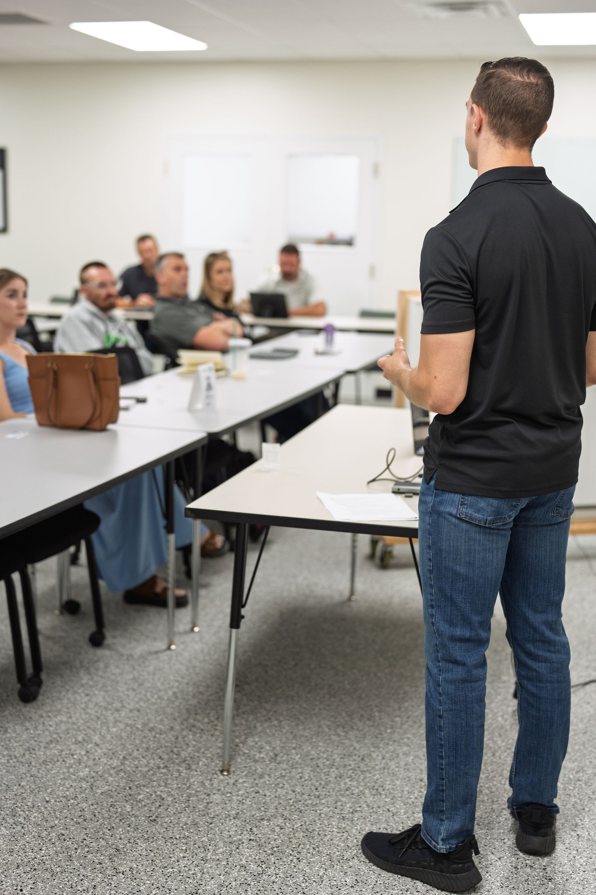 Group of people posing in a meeting room, some wearing grey shirts. A screen is behind them.