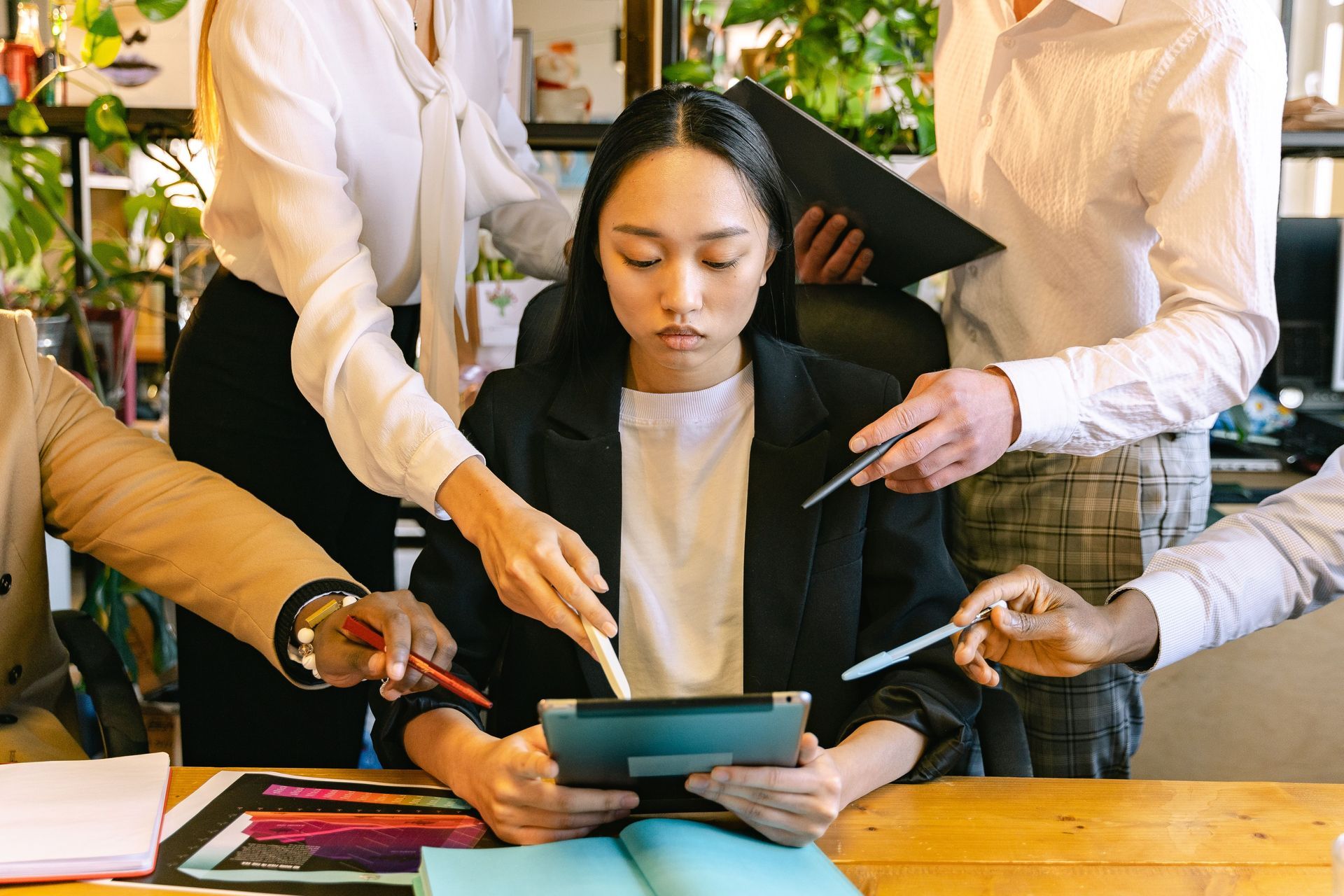 Team reviewing a tablet together at a desk in a bright office setting
