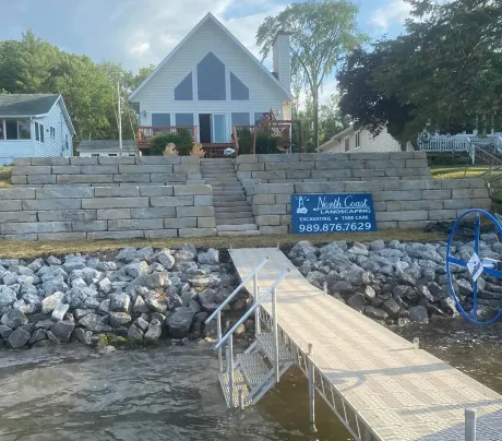 A dock with stairs leading up to a house