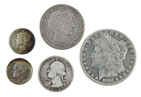 Five old U.S. coins on a white background, including dimes and larger silver coins.