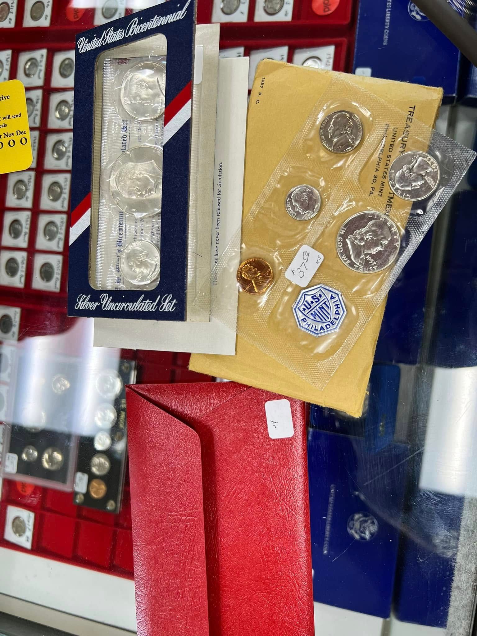 Assorted coin display packs in blue, red, and tan packaging on a shop shelf.