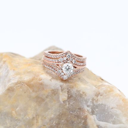 Rose gold diamond ring on a pale stone surface