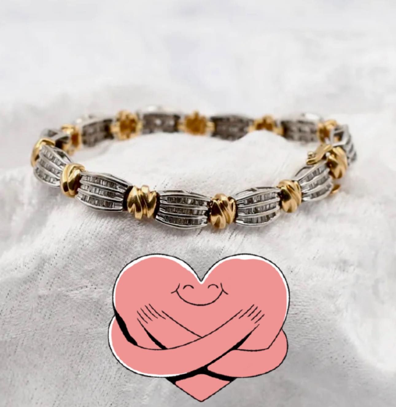 Gold and silver beaded bracelet on a white fur surface with a pink heart graphic below