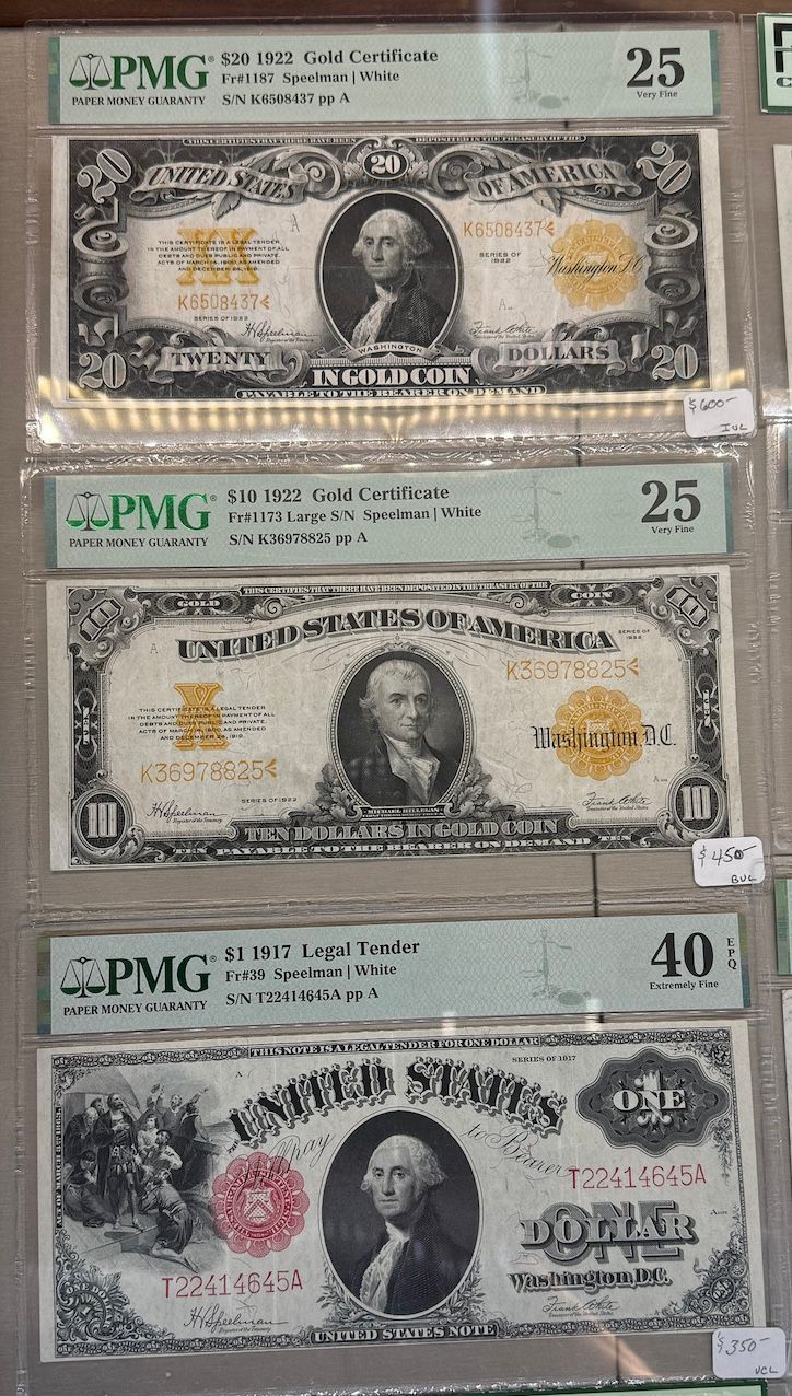 Three graded U.S. banknotes displayed vertically, two $10 bills and one $20 bill in protective holders.