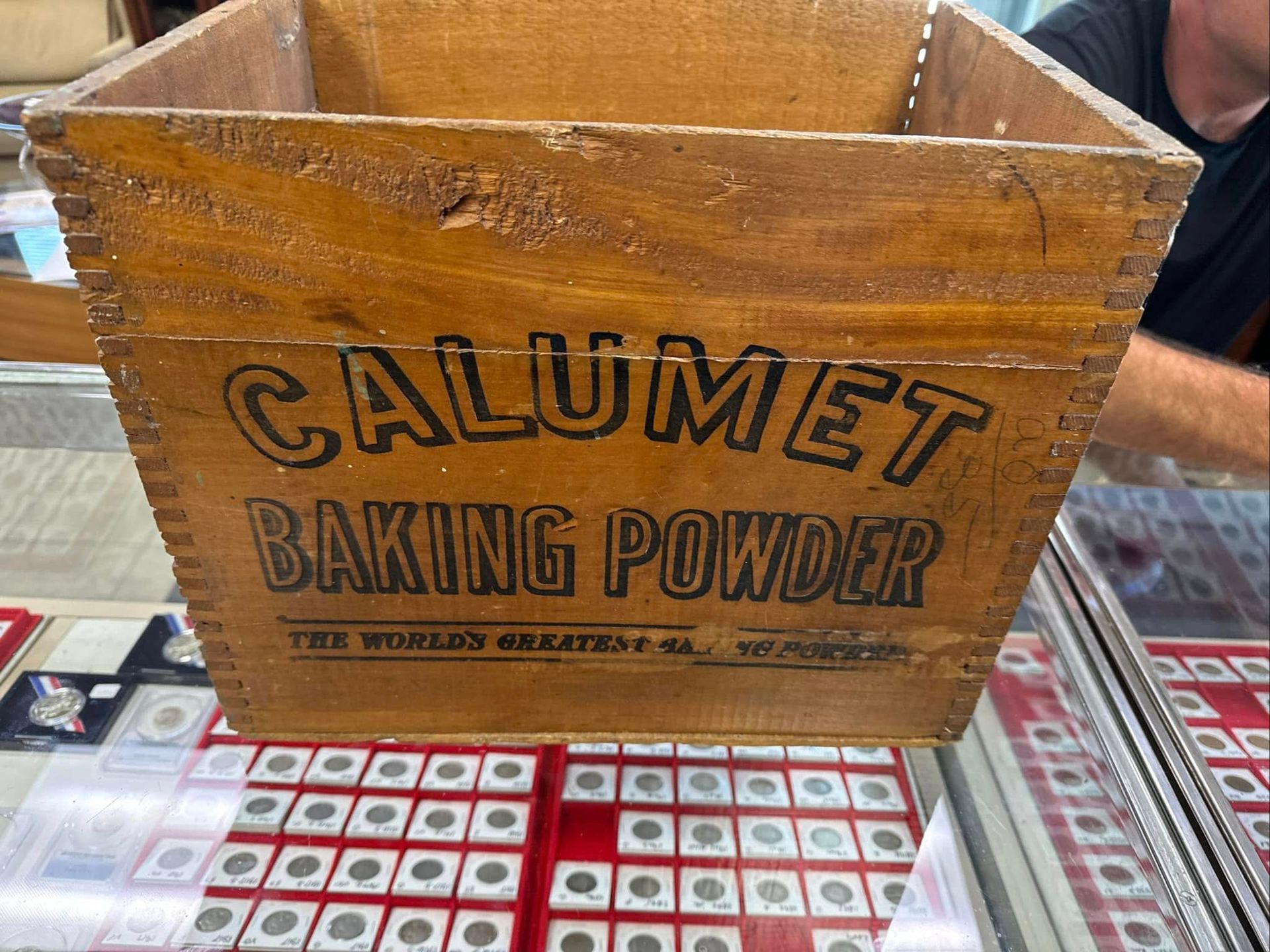 Wooden Calumet baking powder crate with faded black lettering on a tabletop display