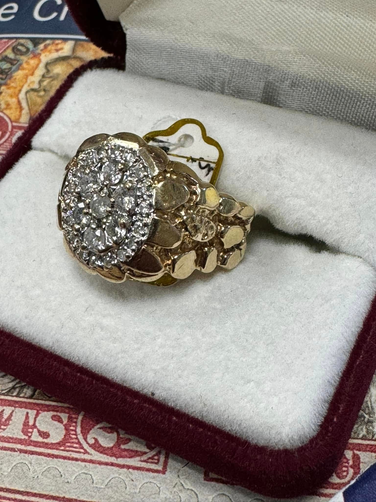 Gold ring with a large round diamond cluster, displayed in a red-and-white jewelry box
