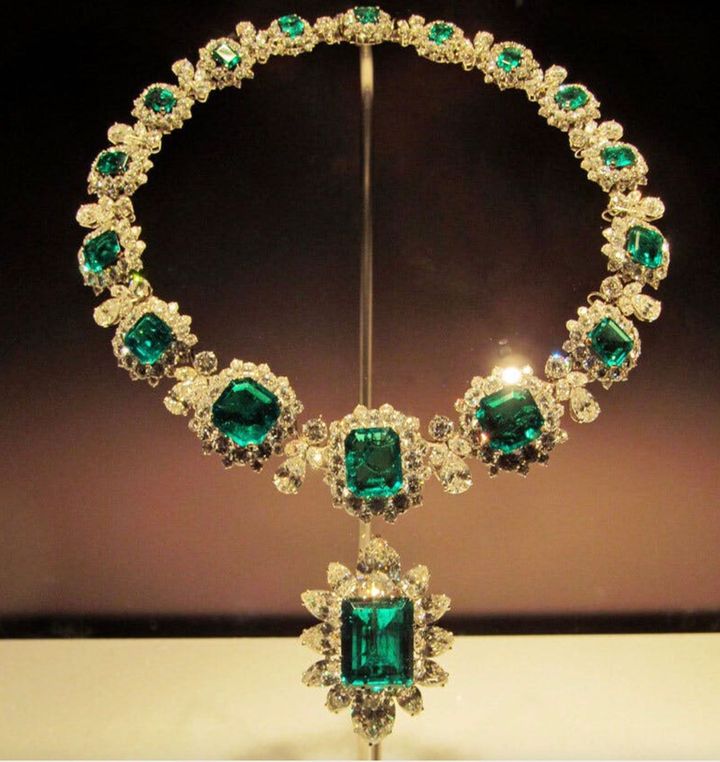 Emerald and diamond necklace with a large pendant on a display stand