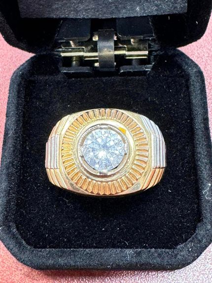 Gold and silver diamond ring displayed in a black velvet jewelry box