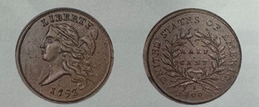 Two sides of a brown U.S. Liberty coin, profile and wreath designs on a plain background