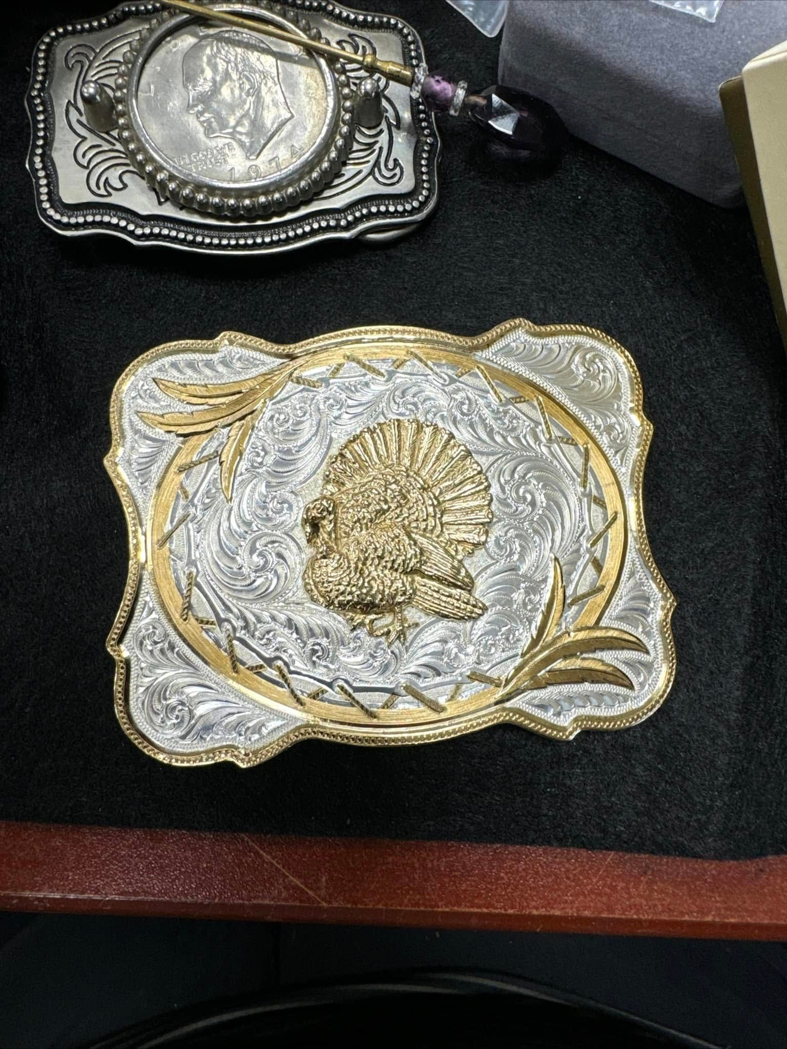 Two ornate silver and gold decorative trays on a dark surface