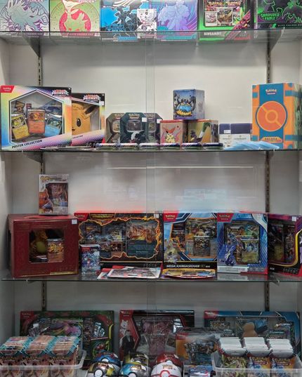Shelves filled with colorful boxed trading card game sets and booster packs in a store display.