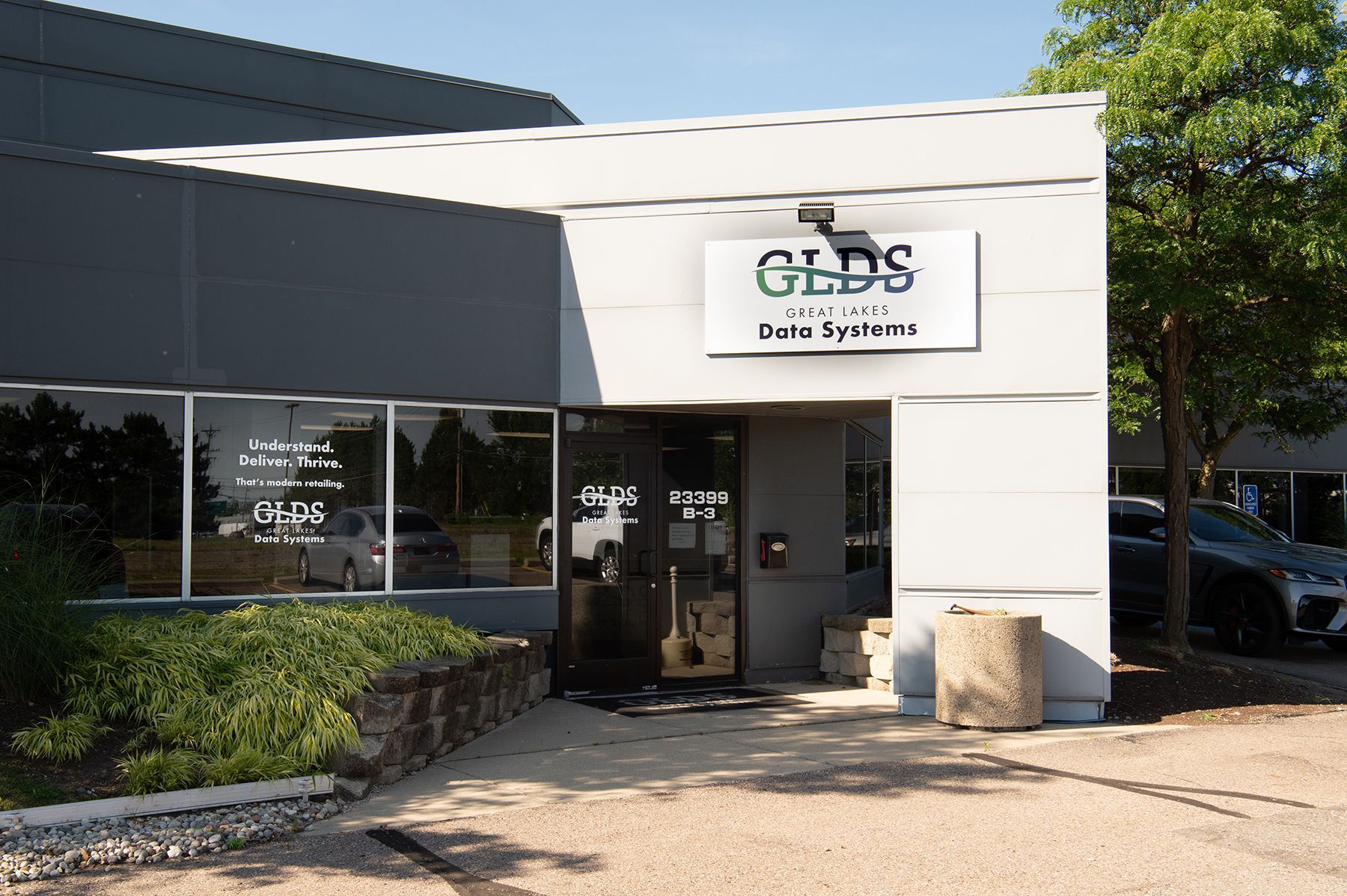 GLDS Doga Institute storefront with white facade, glass entrance, and greenery outside