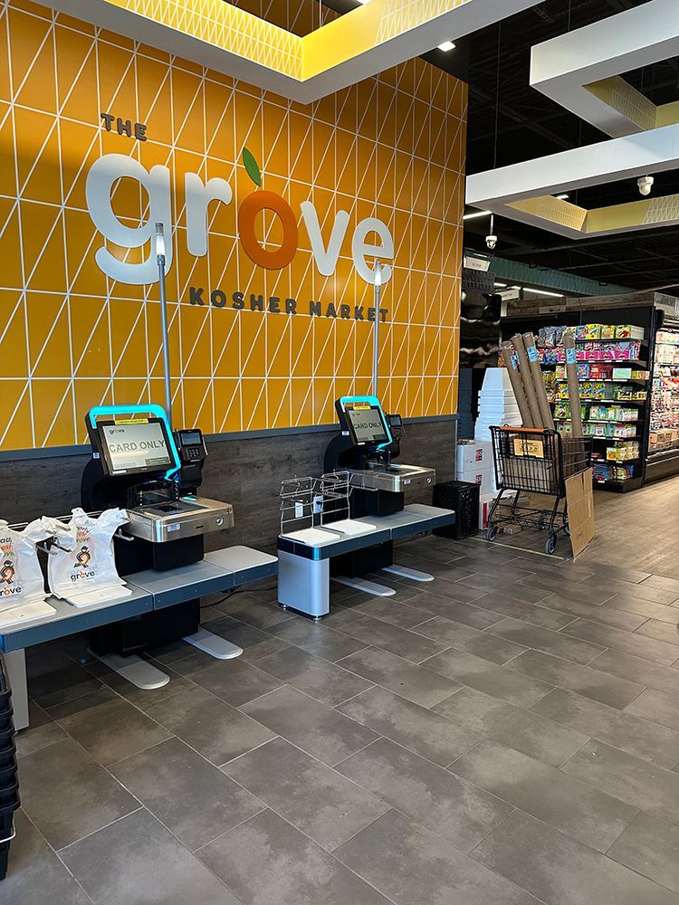 Grove grocer entrance with self-checkout stations and orange tiled wall