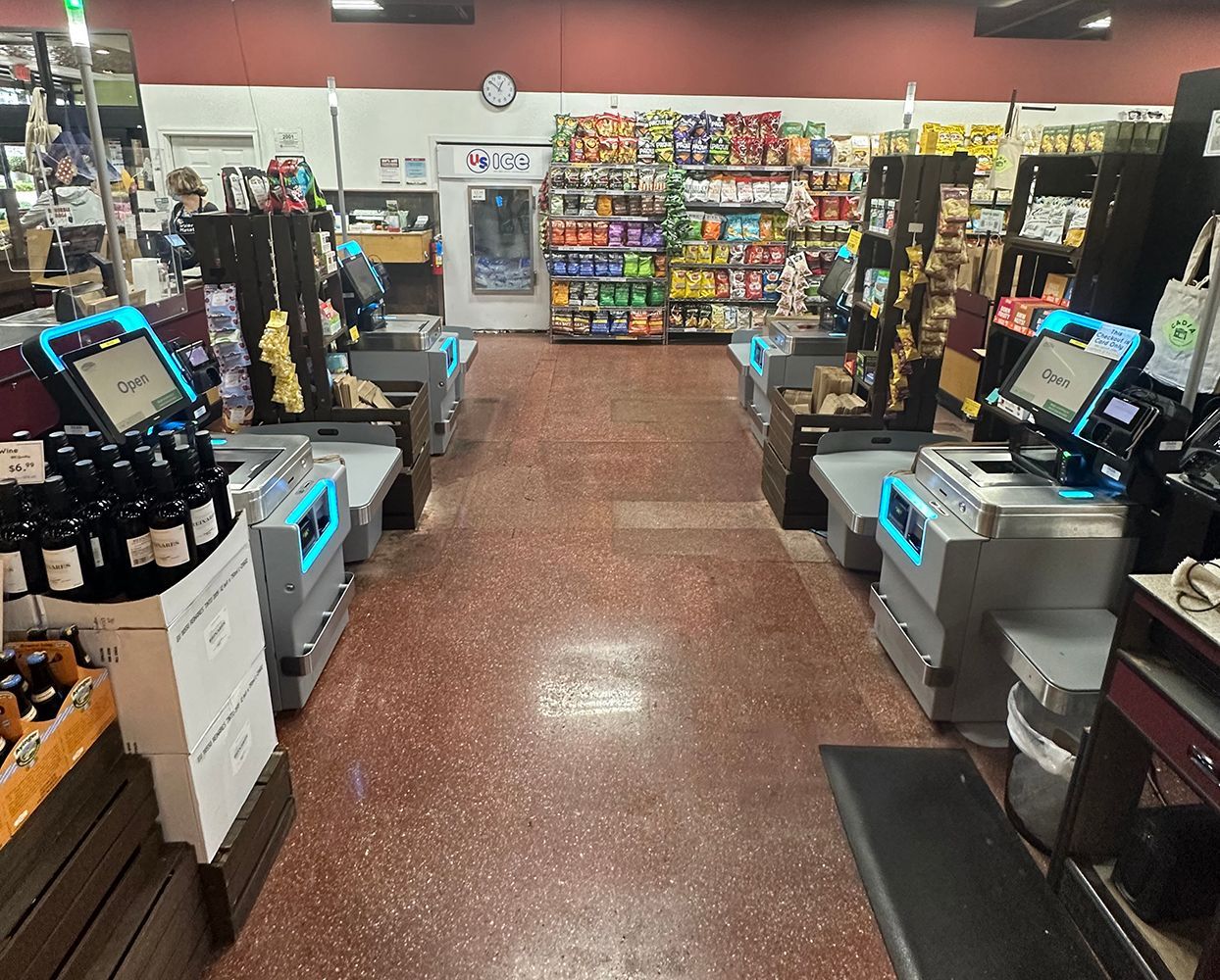 Grocery store checkout lanes with bright displays and stocked shelves in the background