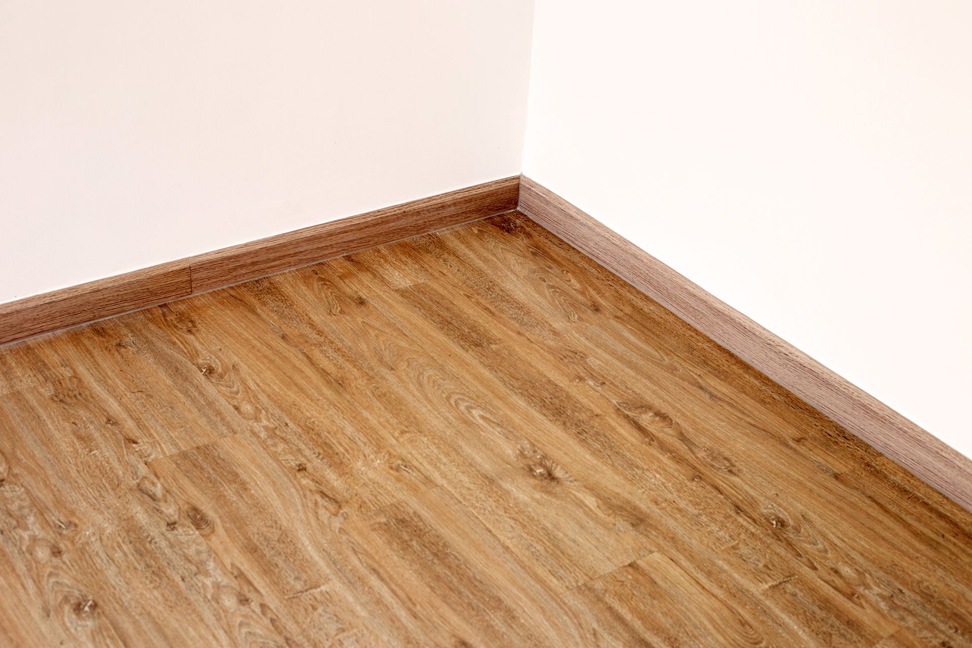 A room with a wooden floor and a white wall.