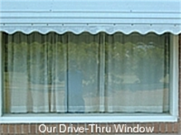 A closed window covered by a light-colored curtain, featuring the text 