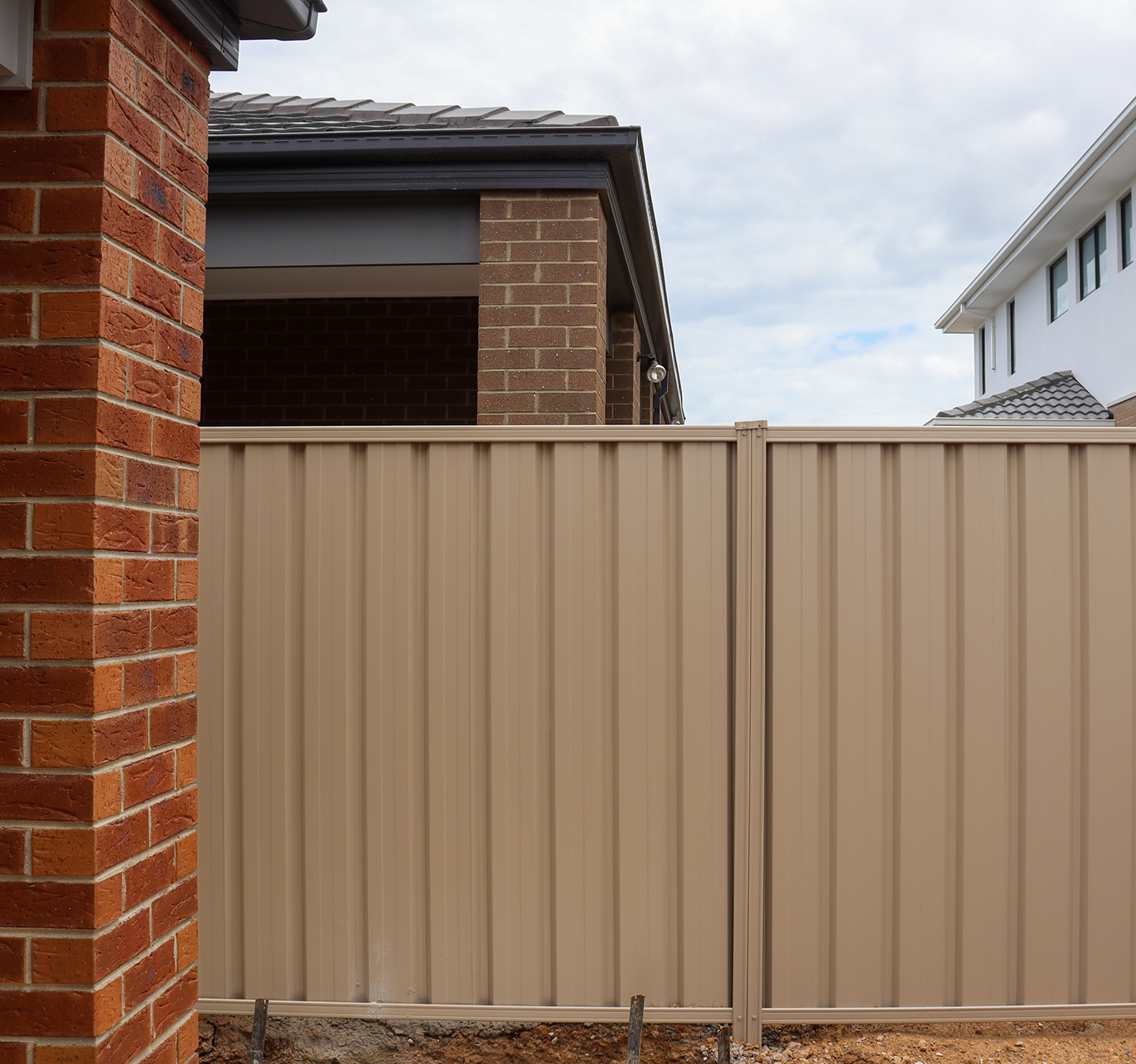 A brick building with a tan fence in front of it