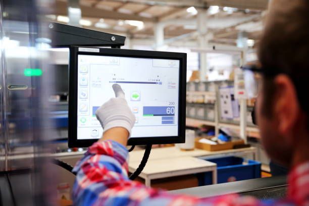 A man is using a computer in a factory.