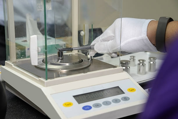 A person is working on a scale in a laboratory.