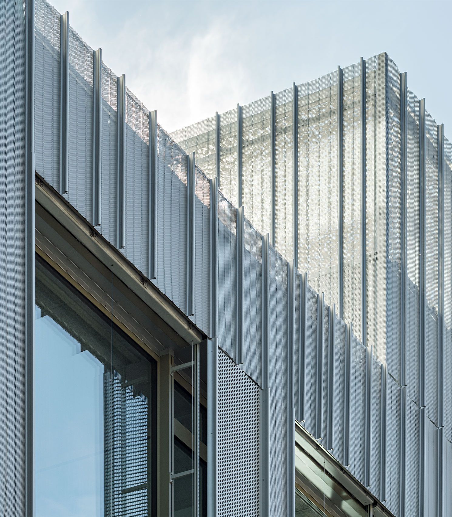 Modern building exterior with silver metal facade and large windows.