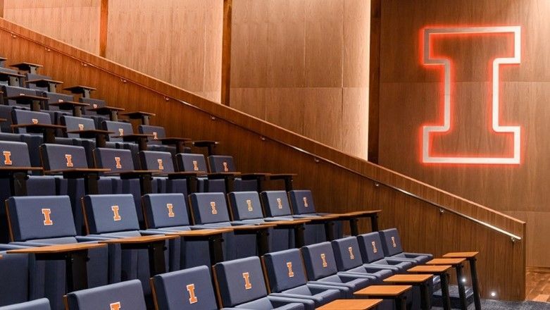 Auditorium seating with wooden accents and the University of Illinois