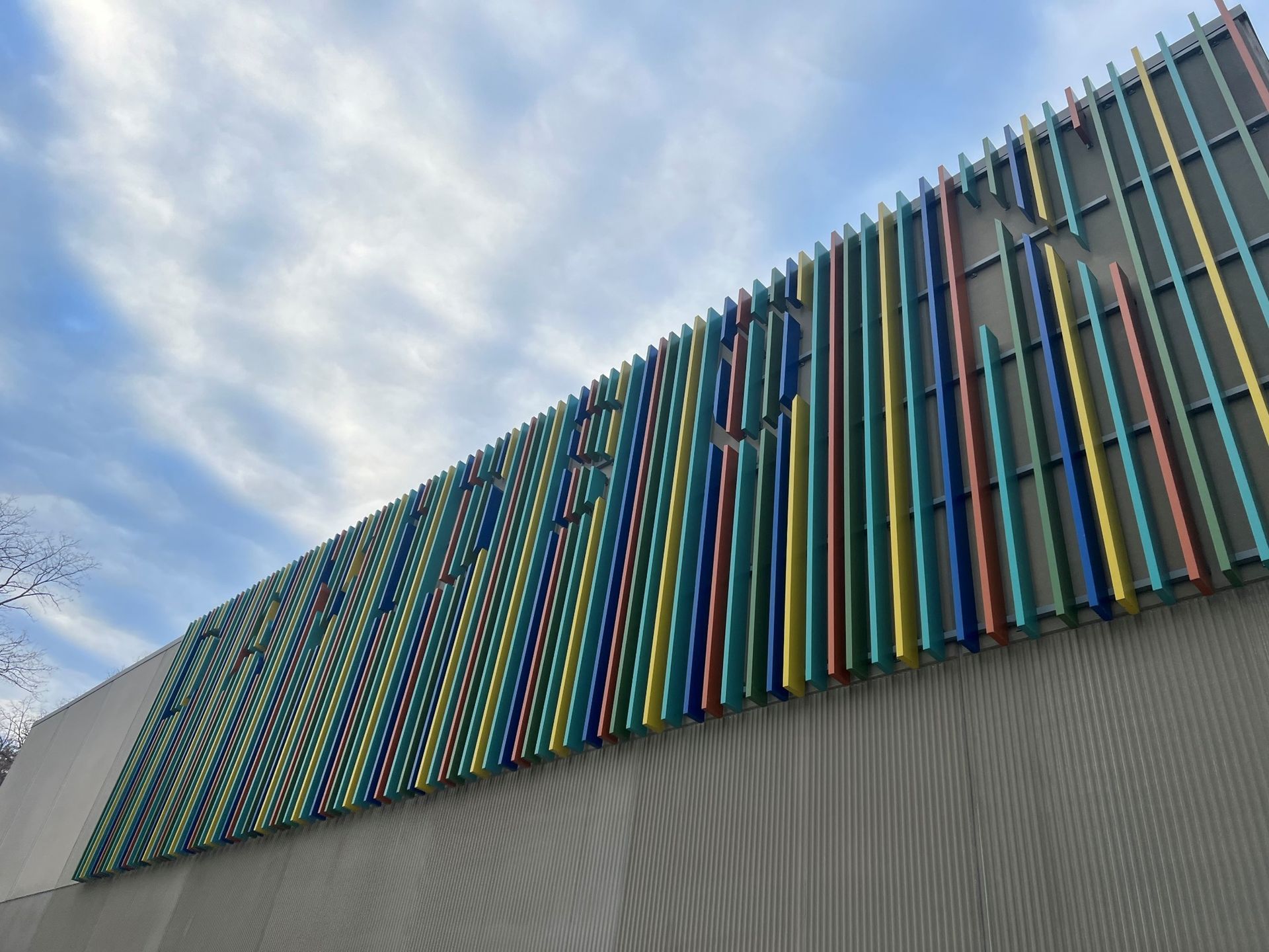 Colorful vertical bars form a building facade, with the word