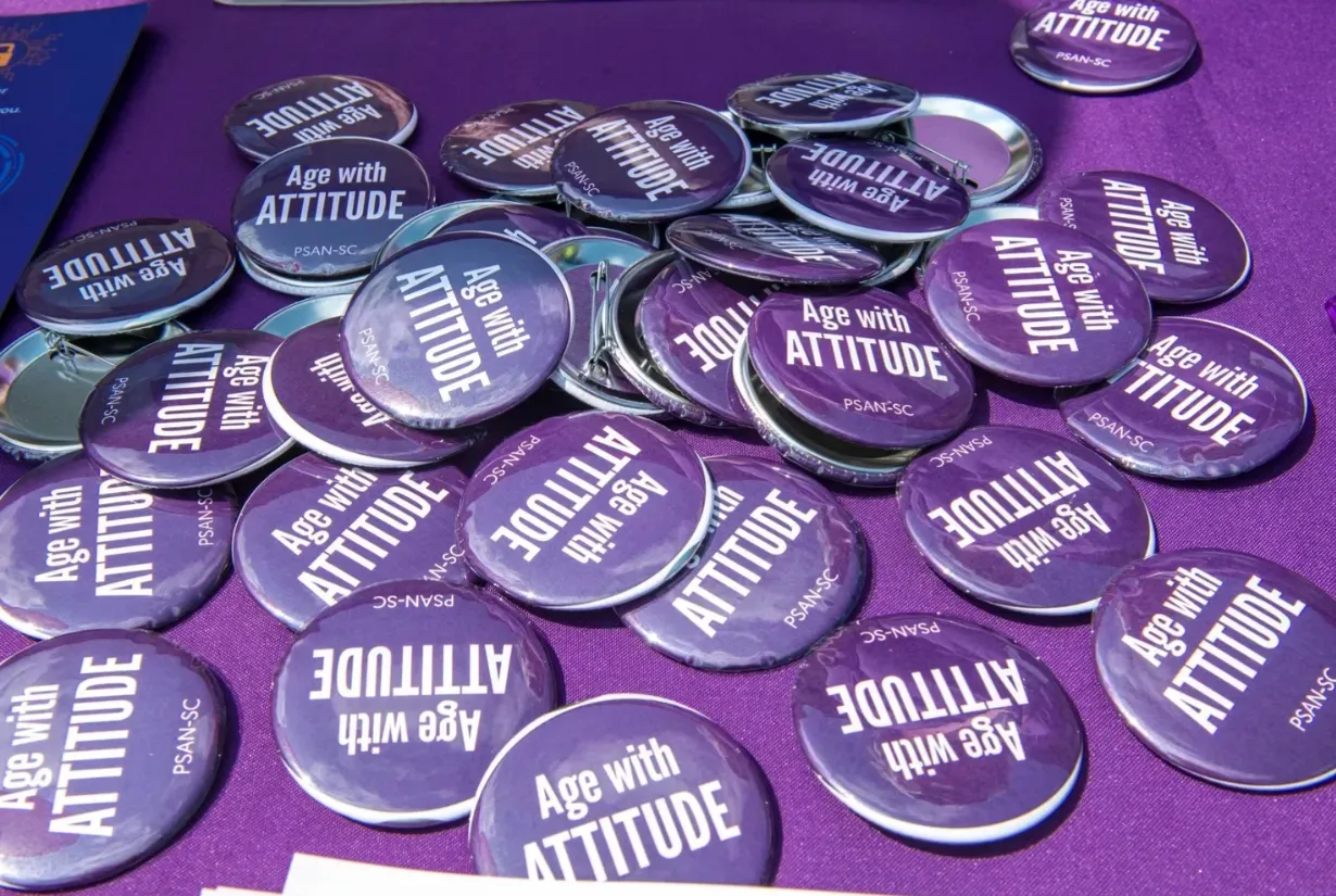 Purple buttons with the words “Ag with ATTITUDE” scattered on a purple surface