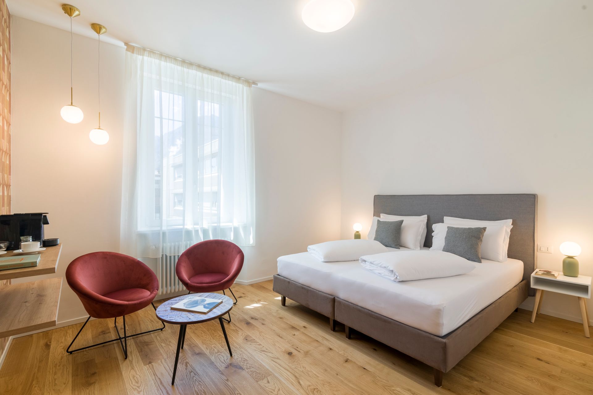 Ein Hotelzimmer mit einem Bett, zwei Stühlen, einem Tisch und einem Fenster.