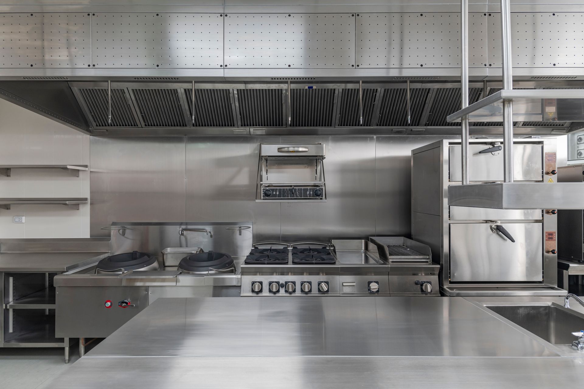 Commercial kitchen with stainless steel stoves, ovens, and countertops.
