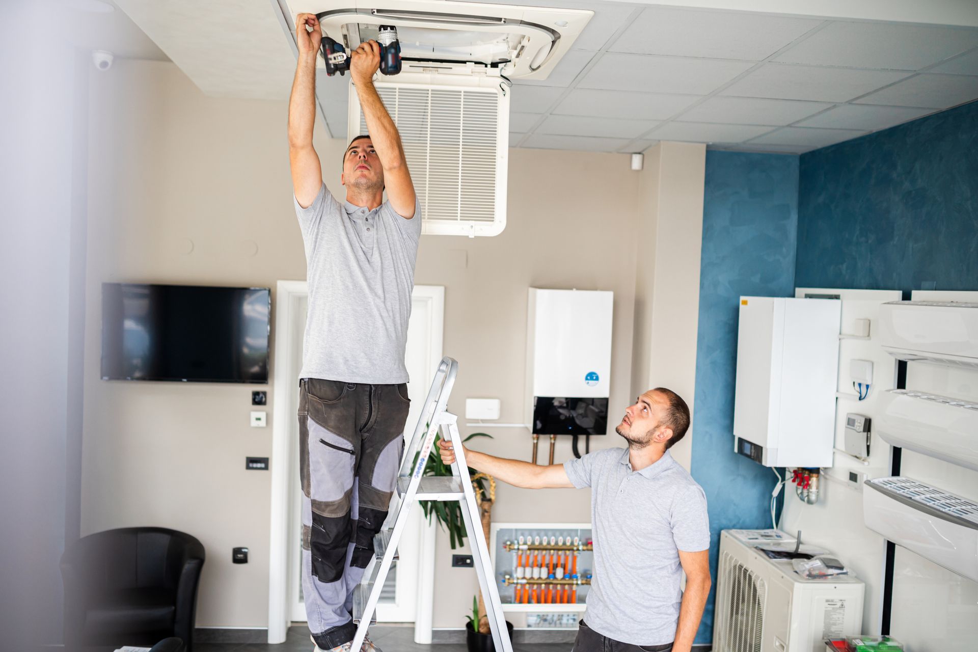 Two Men are working on a Ceiling Fan in a Room - Hialeah, FL - Cajigas Air Conditioning LLC