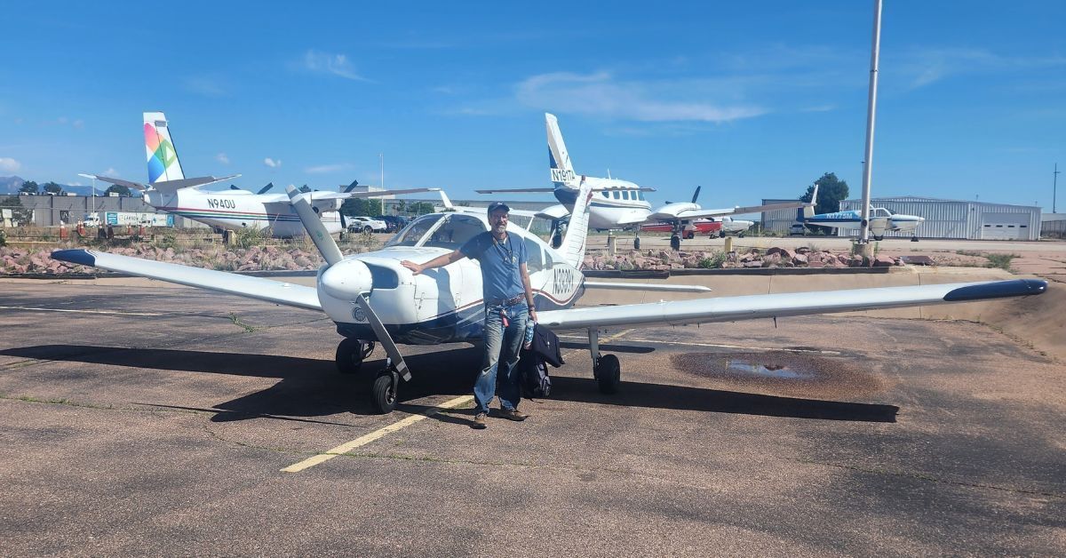 Man Standing Next to Airplane