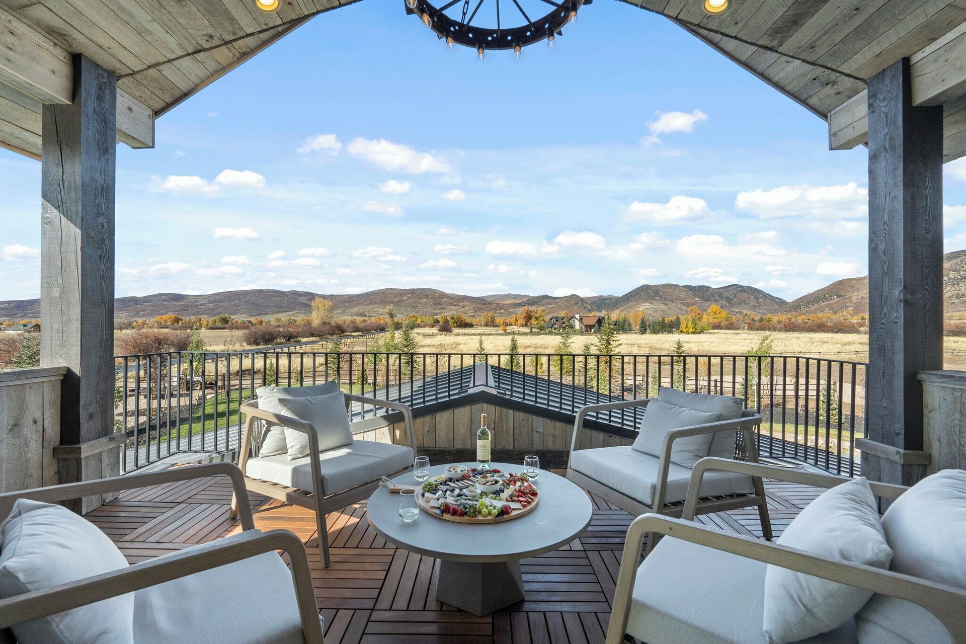 Outdoor patio with seating, a table with snacks, and a view of a valley.