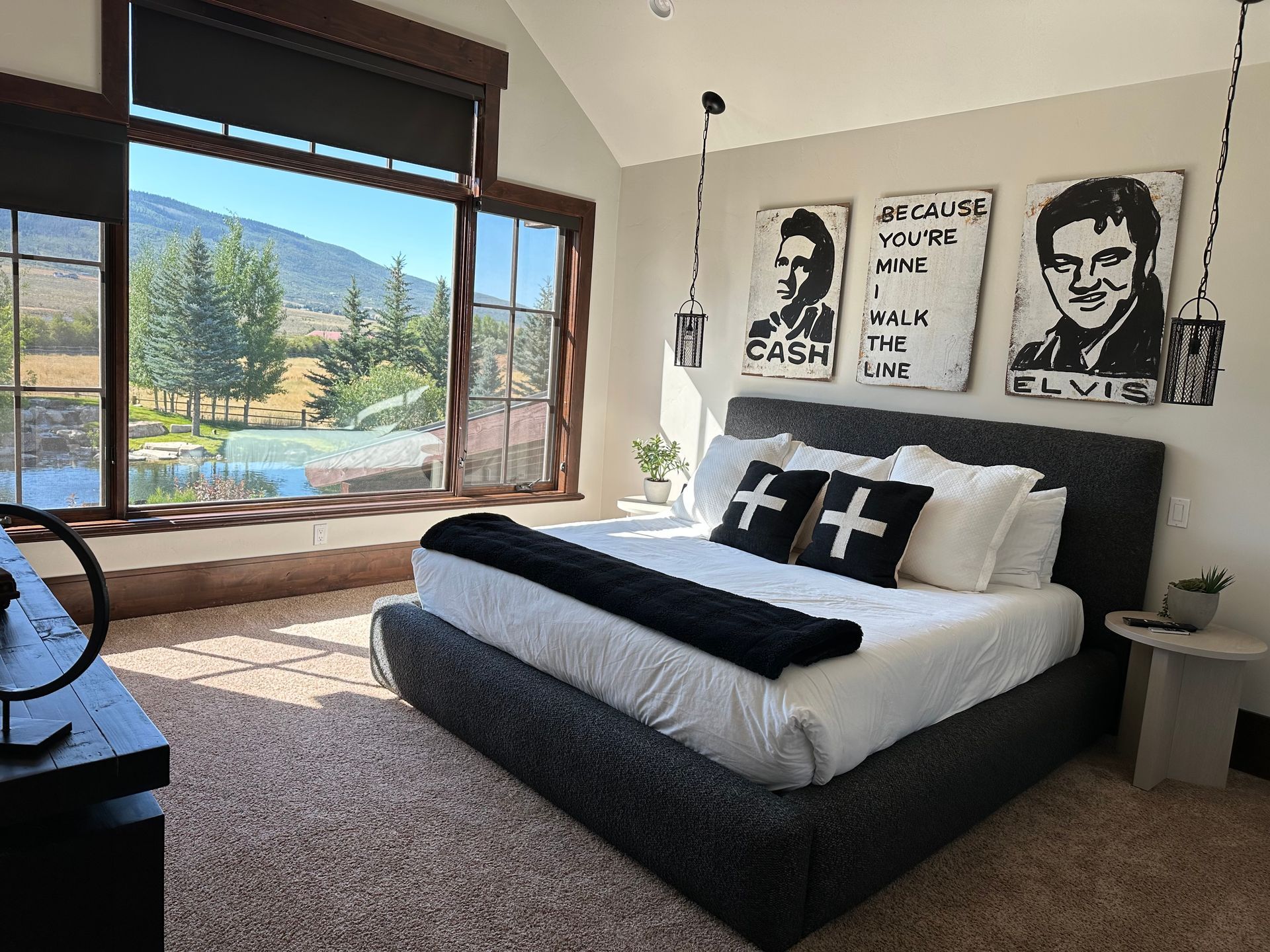Bedroom with a large window, bed, and Elvis and Johnny Cash artwork.