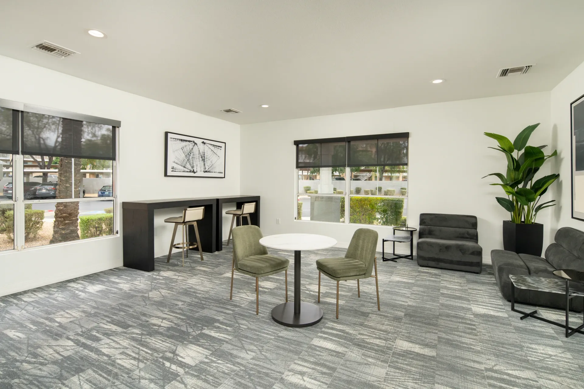 Modern lounge area with high-top table, chairs, and sofa at Heritage at Deer Valley in Phoenix, AZ.