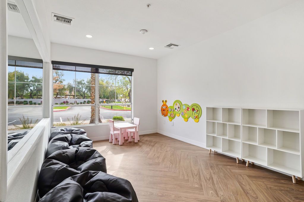 Bright children's playroom with large windows, kid-sized table and cubby shelves at Heritage at Deer Valley in Phoenix, AZ.