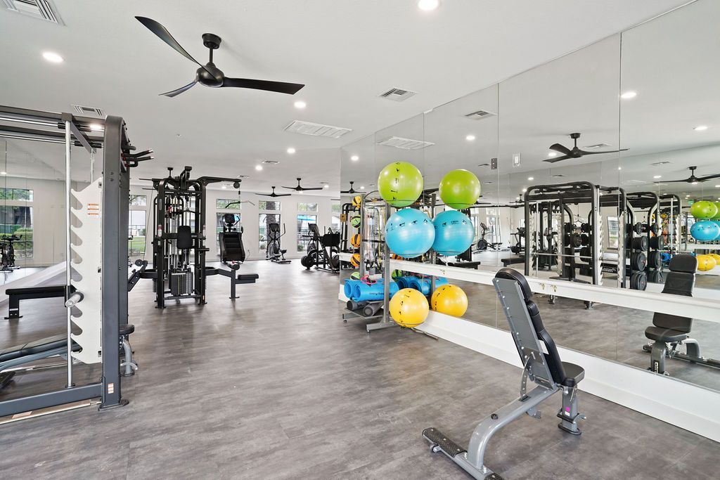 Bright apartment gym with weight machines, free weights, and mirrors at Heritage at Deer Valley in Phoenix, AZ.