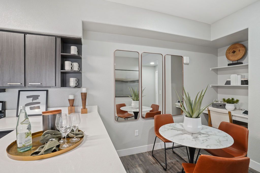 Modern apartment kitchen and dining area with a marble round table and plants at Heritage at Deer Valley in Phoenix, AZ.