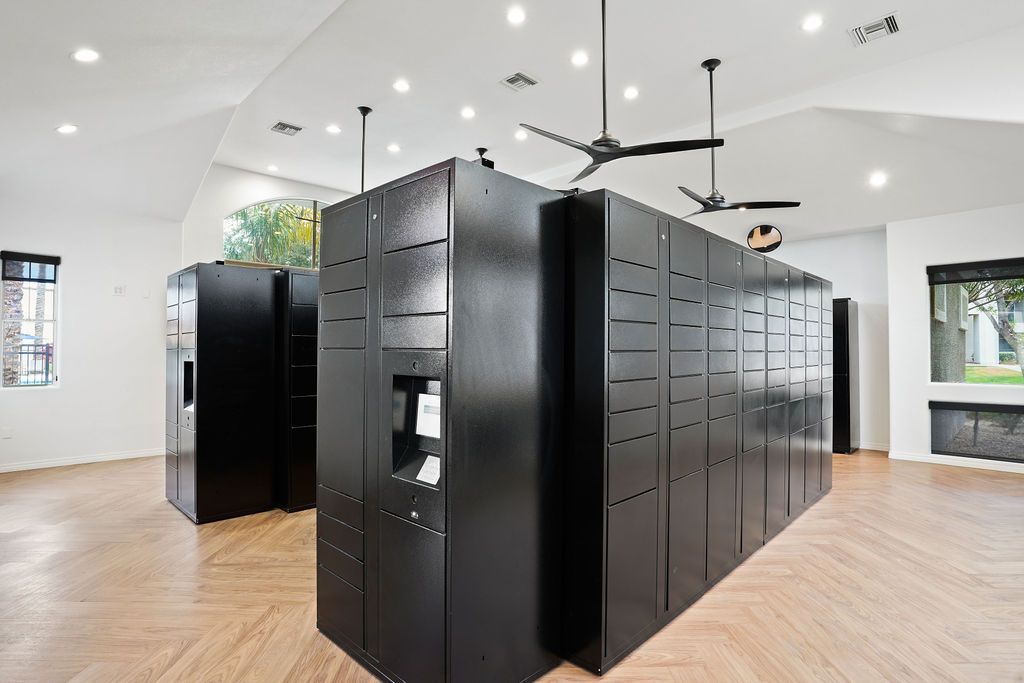 Row of tall black storage lockers in a bright, modern community room at Heritage at Deer Valley in Phoenix, AZ.
