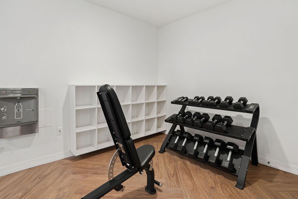 Fitness room with bench, dumbbell rack, and cubby storage at Heritage at Deer Valley in Phoenix, AZ.