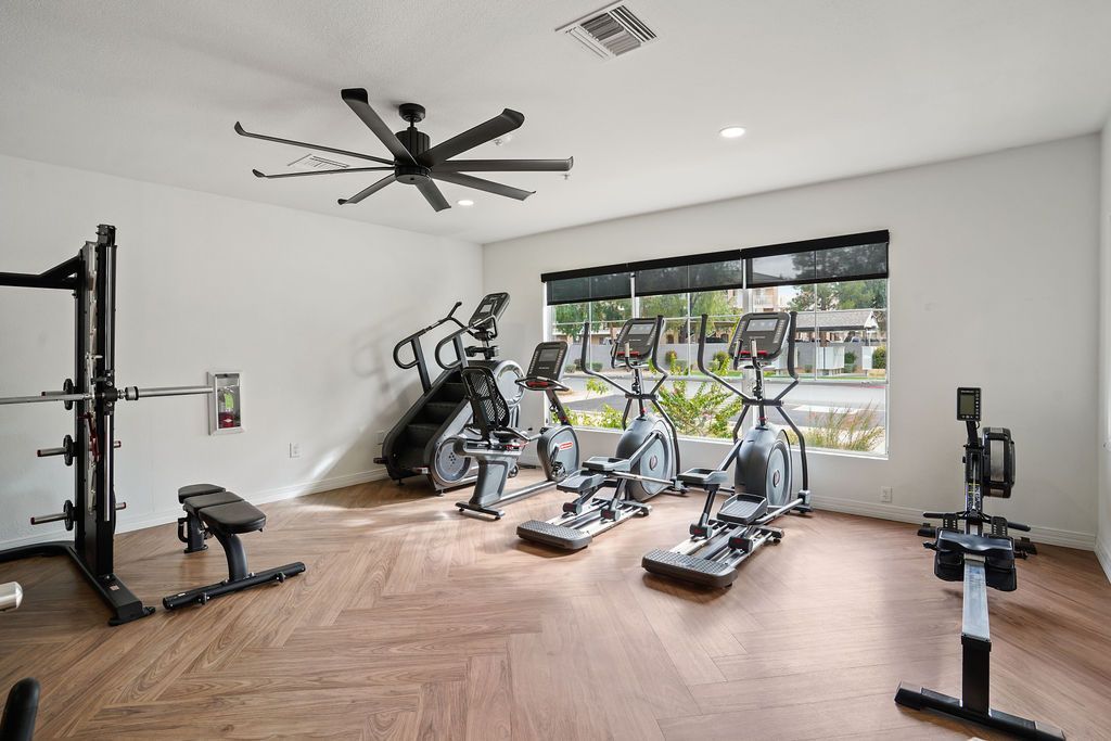 Interior community gym with treadmills, weight rack, and a bench at Heritage at Deer Valley in Phoenix, AZ.