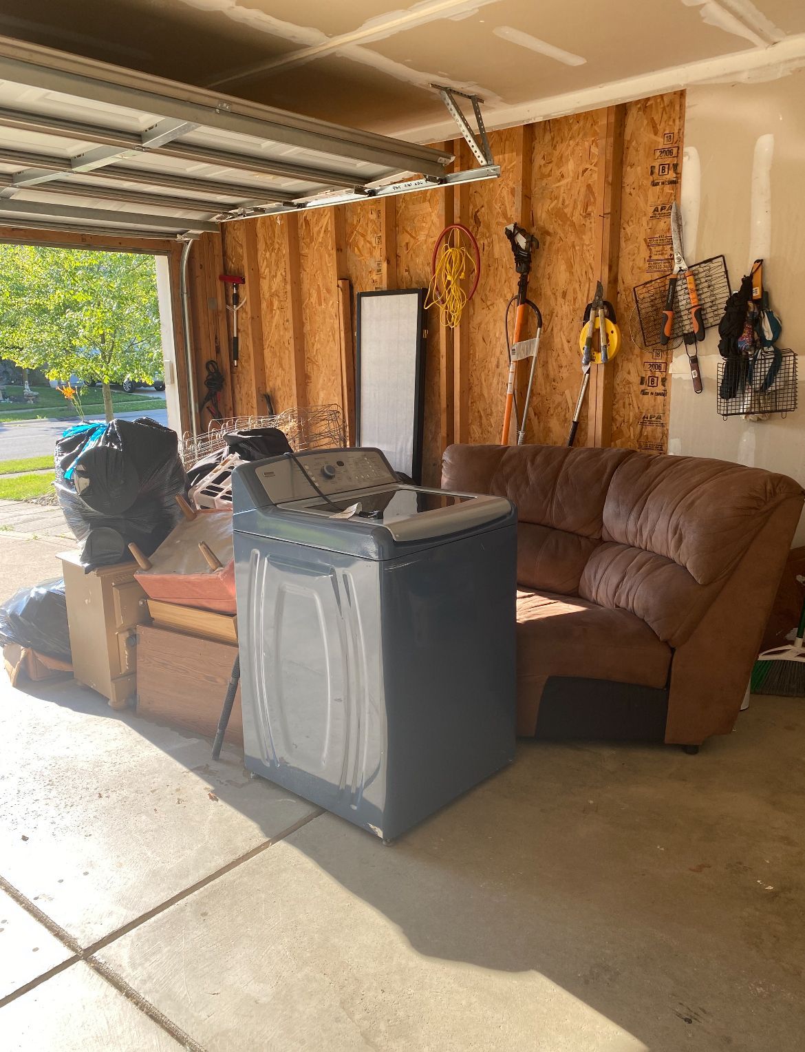 A garage filled with furniture and a washer and dryer.