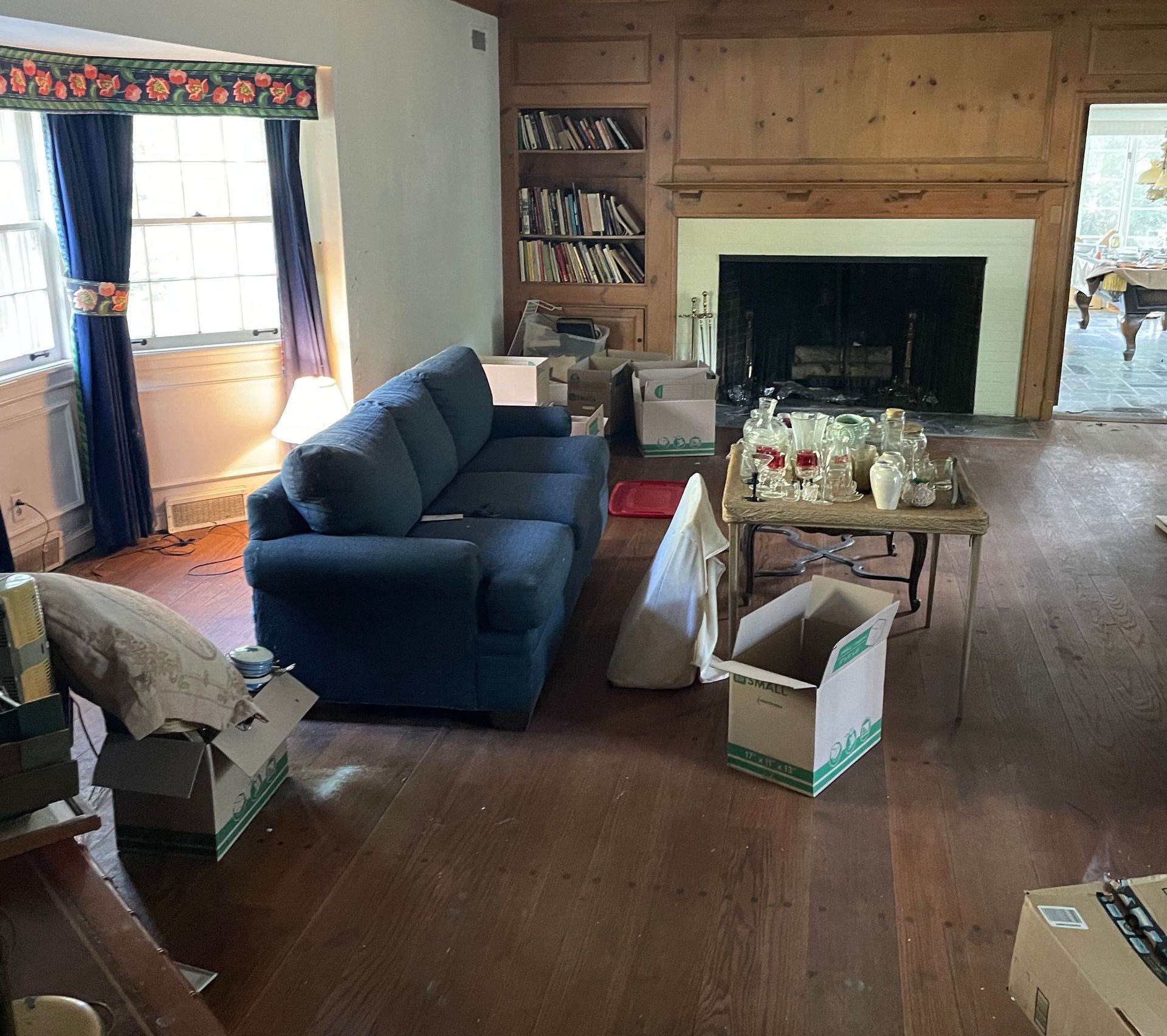 A living room with a blue couch and a fireplace
