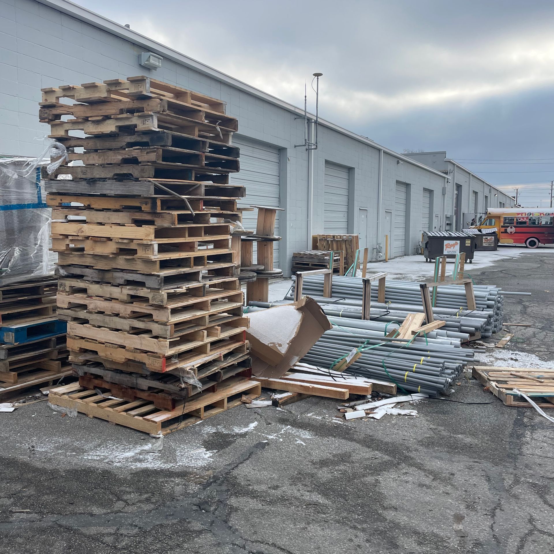 A stack of wooden pallets sits in front of a building