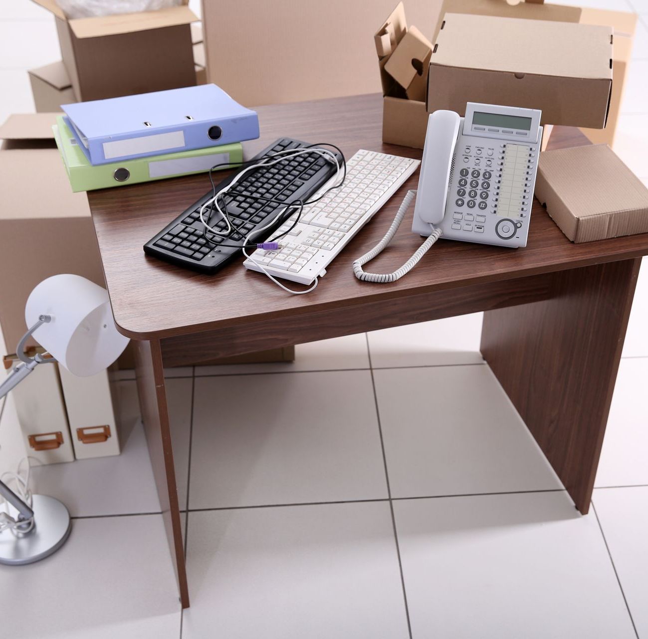 A desk with a keyboard and a telephone on it