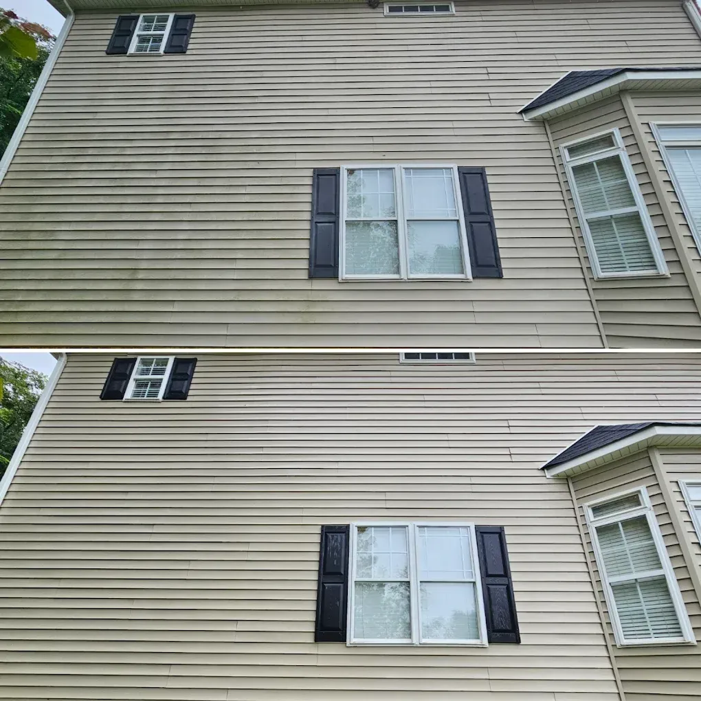 Two-story beige house exterior with white-trimmed windows and dark shutters