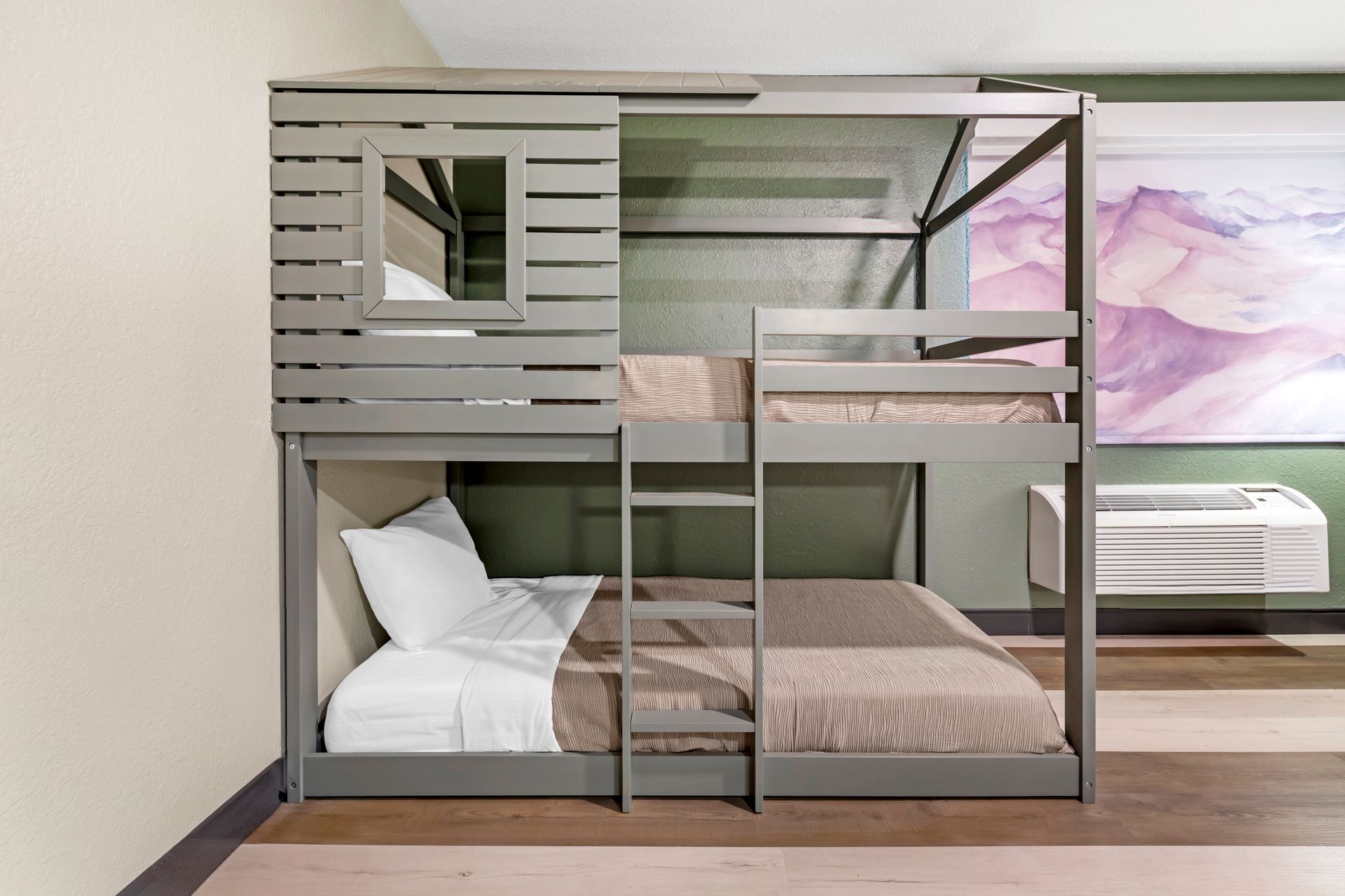 A bunk bed in a room with a painting on the wall.
