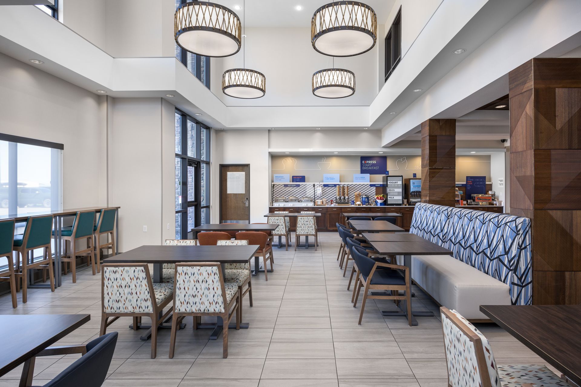 A hotel breakfast seating area with tables and chairs.