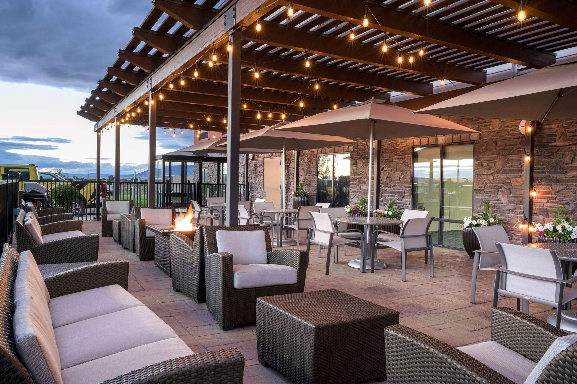 There are a lot of chairs and tables on the patio.